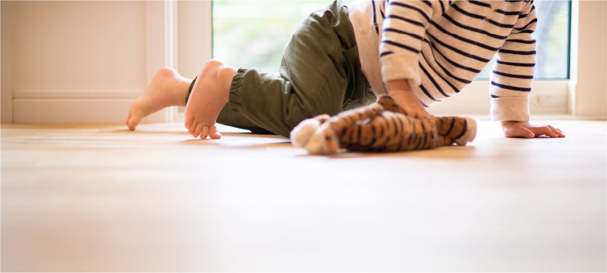 暖かい床に寝そべる赤ちゃん